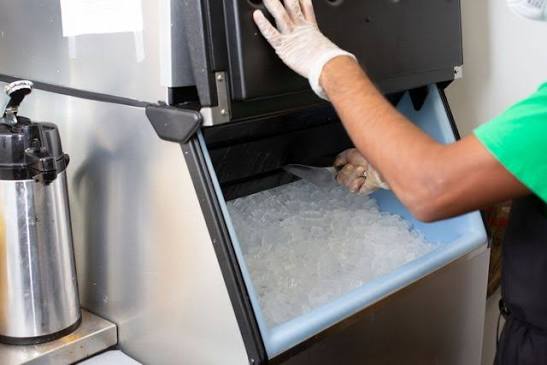 Commercial ice machine full of ice being serviced