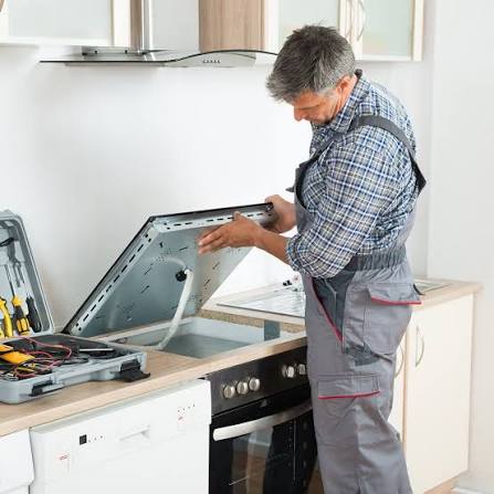 Local technician repairing a cooktop with a full tool kit ready on the counter